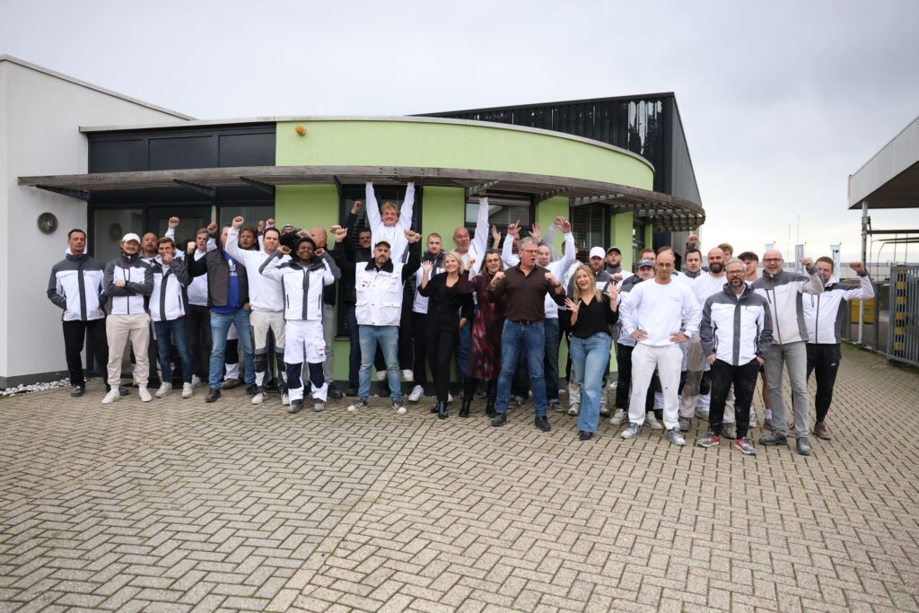 Team van Leusink Wand en Plafondafwerking juichend op de foto.